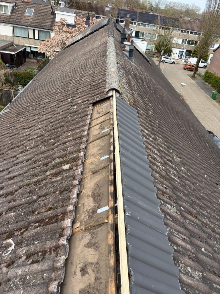 Oude nok verwijderd, nieuwe nokbalk en bovenste rij dakpannen geplaatst