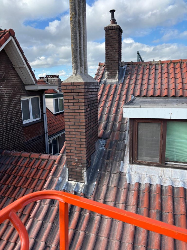 Gerenoveerde gemetselde schoorsteen met nieuw loodwerk op een pannendak