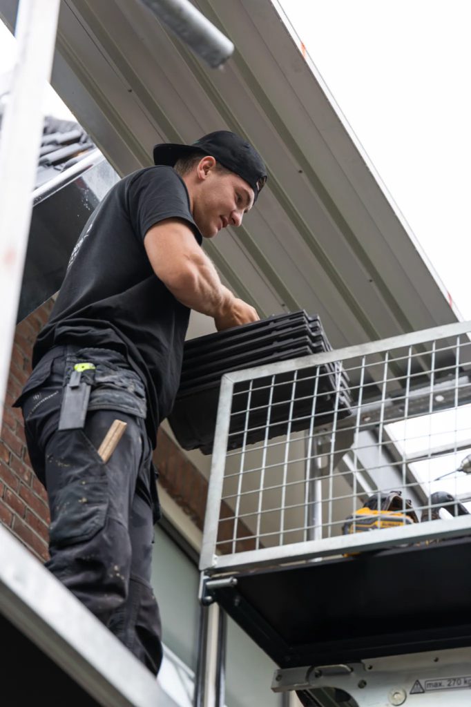Dakdekker aan het werk bij een dakkapel